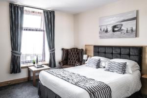 um quarto com uma cama grande e uma cadeira em Seaview Hotel em Peterhead