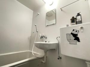 a bathroom with a sink and a panda on a chair at 东京中心 新装修温馨宽敞公寓 202交通方便两条地铁直达上野新宿东京 in Tokyo