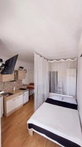 a bedroom with a large white bed and a kitchen at Studio Apartment 'Dream' in Šibenik