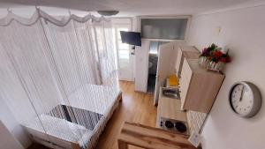 een kleine woonkamer met een keuken en een klok bij Studio Apartment 'Dream' in Šibenik