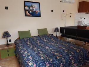 ein Schlafzimmer mit einem Bett mit einer Decke darauf in der Unterkunft Nati Stúdió Apartman in Siófok