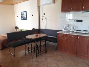 una cocina con una mesa pequeña y una cocina con barra en Nati Stúdió Apartman en Siófok
