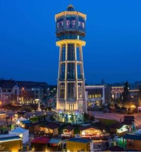 una torre de control en una ciudad por la noche en Nati Stúdió Apartman en Siófok
