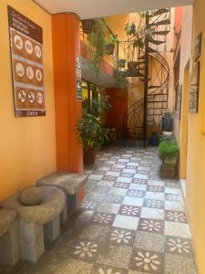 a hallway with benches and plants in a building at La Casa de Zarela in Huaraz