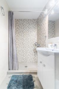 a bathroom with a white sink and a shower at Renovated Loft near the Center in Heraklio