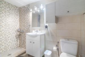 a bathroom with a white toilet and a sink at Renovated Loft near the Center in Heraklio Town