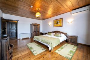 Hotel Complex Zlatnata Ribka في دورانكولاك: غرفة نوم بسرير وسقف خشبي