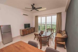 uma sala de estar com mesa e cadeiras e uma cozinha em 3 bedroom condo with Pool near Queensbay Mall em Bayan Lepas