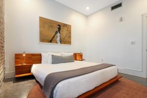 ein Schlafzimmer mit einem großen Bett und einem Gemälde an der Wand in der Unterkunft Roami at Motorworks in New Orleans