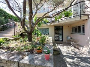 une maison avec un arbre et des fleurs dans une cour dans l'établissement studio indépendant près du centre ville, à Nîmes