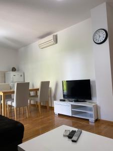 a living room with a television and a table with chairs at Apartment 28 in Ljubuški