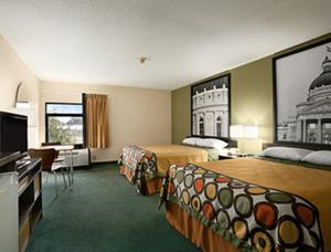 a hotel room with two beds and a television at Super 8 by Wyndham Columbia City in Columbia City