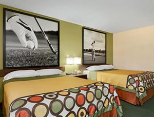 a hotel room with two beds and pictures on the wall at Super 8 by Wyndham Columbia City in Columbia City