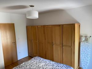 1 dormitorio con 1 cama y un gran armario de madera en Apartment 28, en Ljubuški