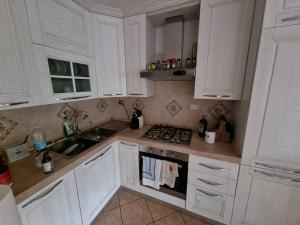 een keuken met witte kasten en een fornuis met oven bij Ostia house in Lido di Ostia