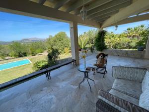 un osito de peluche sentado en un patio con una mesa de cristal en Villa Florida Luxury Villa with huge pool en Pollença