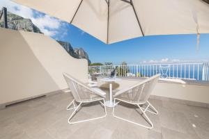 a table and chairs in a room with a balcony at Casa Dani Capri in Capri