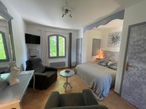 a bedroom with a bed and a couch and a chair at Domaine de Majastre in Bauduen