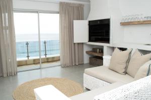 a white living room with a view of the ocean at Diaz Ocean View Hotel in Mossel Bay