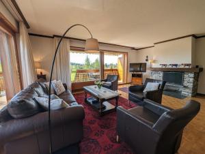a living room with leather furniture and a fireplace at Beau Vallon 04 in Crans-Montana
