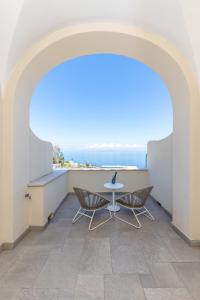 een kamer met een tafel en stoelen en uitzicht op de oceaan bij Casa Dani Capri in Capri