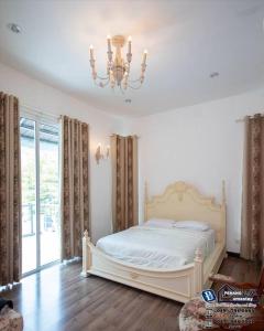 1 dormitorio con cama blanca y lámpara de araña en Teluk Bahang European Style SemiD 4 Bedrooms 10ppl, en Teluk Bahang