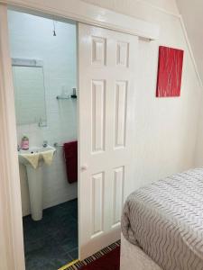 ein Schlafzimmer mit einem Bett und ein Badezimmer mit einem Waschbecken in der Unterkunft Fairfax in Skegness