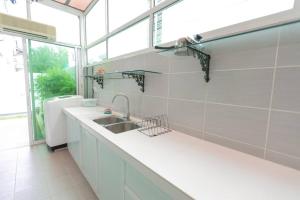 cocina blanca con fregadero y ventana en Teluk Bahang European Style SemiD 4 Bedrooms 10ppl, en Teluk Bahang