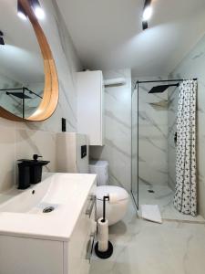 a white bathroom with a sink and a shower at Apartamenty Ski & Fun Spokojna in Wisła