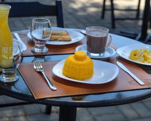 una mesa con platos de comida y bebidas. en Pousada Primavera, en Parnaíba