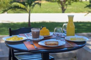 a table with plates of food and a bottle of orange juice at Pousada Primavera in Parnaíba