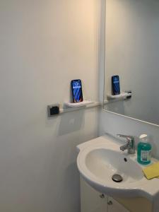 W białej łazience znajduje się umywalka i lustro. w obiekcie Immense StuDio 51 jusqu'à 4 personnes avec vue mer w mieście Saint-Denis