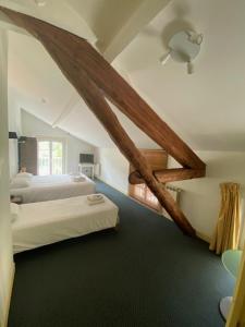 una camera con letto e soffitto con travi a vista di HOTEL ST SEBASTIEN a Roquebillière