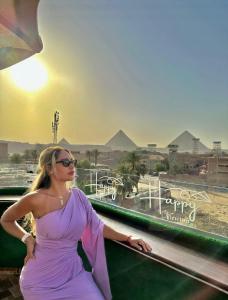 a woman in a purple dress leaning on a railing at Happy View Inn in Cairo