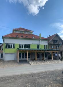 ein grünes und weißes Gebäude mit vielen Fenstern in der Unterkunft Mirocki-Raj in Miroč