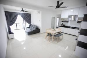 a kitchen and a living room with a table and chairs at Newly Renovated 3Bedroom Vacation Home 6-8pax in Bayan Lepas +15 photos