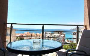 a glass table on a balcony with a view of the ocean at 1bd Sea View Apts Veliki Pjesak "Mula" in Dobra Voda
