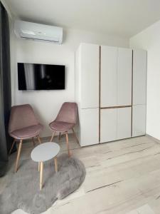 ein Wohnzimmer mit 2 Stühlen und einem Tisch in der Unterkunft SOS CoMFORT 2 LAZUR in Burgas City