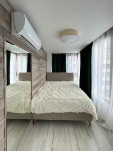 ein Schlafzimmer mit einem Bett und einem großen Spiegel in der Unterkunft SOS CoMFORT 2 LAZUR in Burgas City