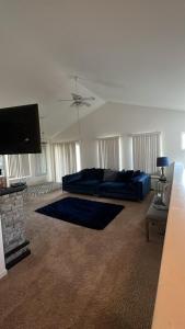 a living room with a blue couch and a flat screen tv at Luxury apartment in suburbs in Sterling Heights
