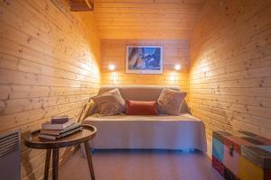 レ・ジェにあるChalet Pandaの木製の壁のベッド1台が備わる小さな客室です。