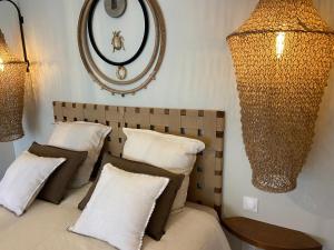una camera da letto con letto, cuscini e specchio di Entre Honfleur et Etretat a Octeville-sur-Mer