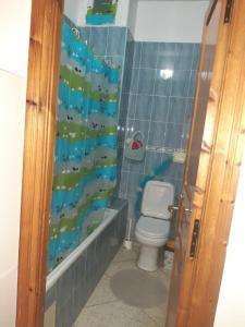 y baño con aseo y cortina de ducha. en Plage en Skhirat