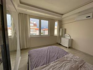 1 dormitorio con cama y ventana grande en 2+1 на первой линии моря, en Çamyolu