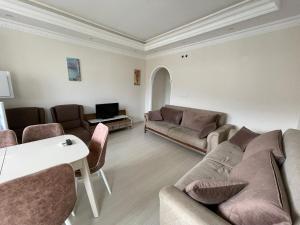 sala de estar con sofás, sillas y mesa en 2+1 на первой линии моря, en Çamyolu