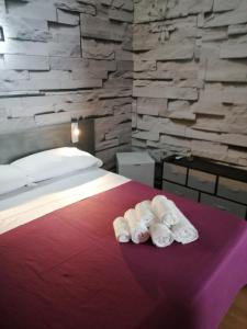 una camera d'albergo con un letto e asciugamani su un tavolo di b&b Le Rocce a San Vito lo Capo