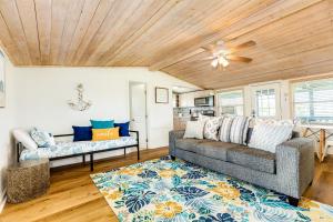 a living room with a couch and a ceiling fan at Cast a Waves - Cute Beach Bungalow - Ocean Views - Walk to the Beach in Galveston
