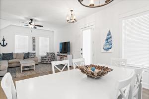 Una sala de estar con una mesa y sillas blancas. en 30A Pet Friendly Beach House - The Charming Blue Haven by Panhandle Getaways, en Santa Rosa Beach