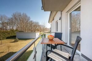 een veranda met een tafel en stoelen op een balkon bij Quartier Görmitz - 44 in Zinnowitz