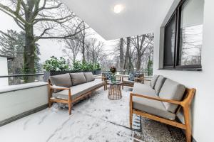 eine Terrasse mit Sofas und einem Tisch auf dem Balkon in der Unterkunft Porsche Villa mit Garten und Garage in Bestlage von Döbling in Wien in Wien